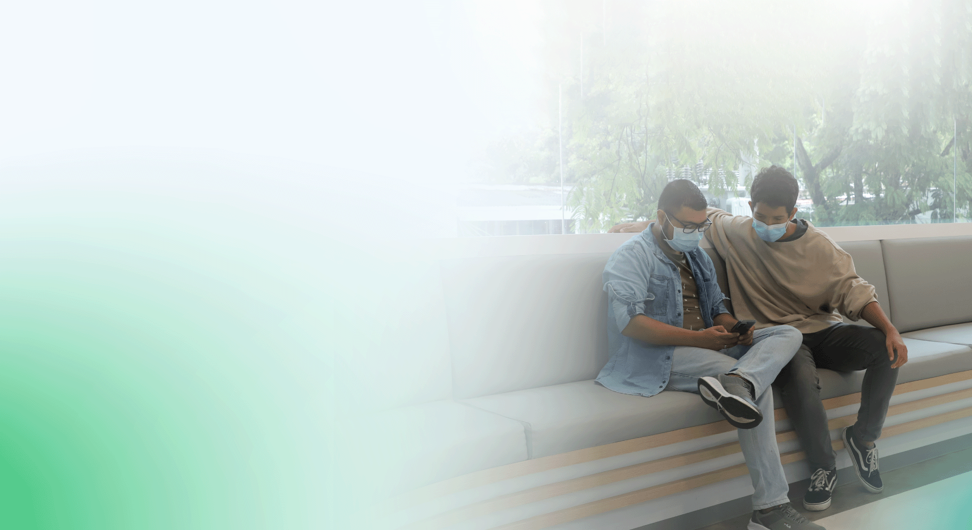 Dos pacientes con mascarillas sentados en la sala de espera de la clínica. Los dos pacientes observan la página de la clínica en un celular. En el fondo se observan árboles y edificios. La imagen esta difuminada sobre blanco y tiene un gradiente verde a la izquierda de la imagen.